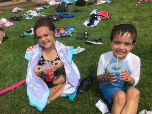 Small boy and girl sip on slushies at the pool